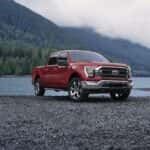 Red 2023 Ford F-150 parked on the edge of a lake