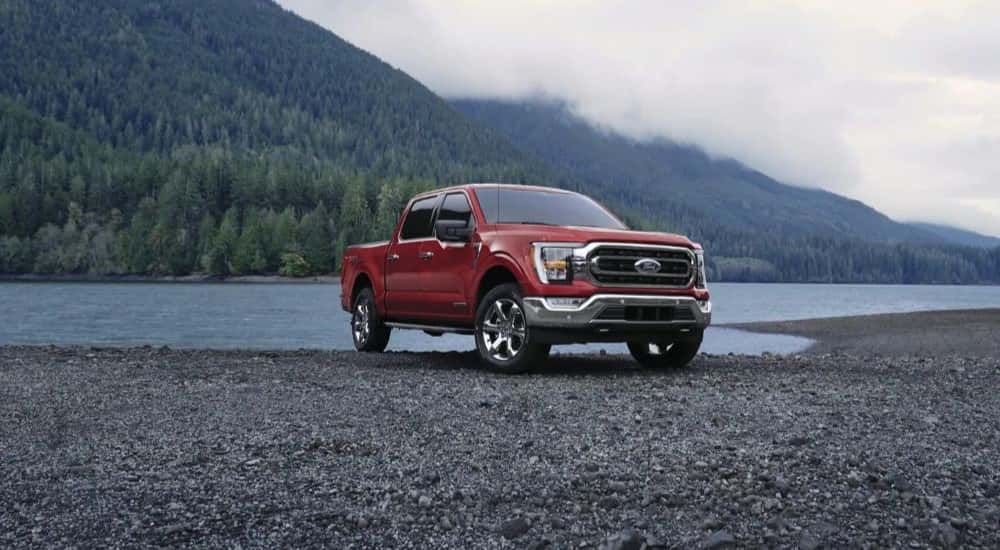 Red 2023 Ford F-150 parked on the edge of a lake