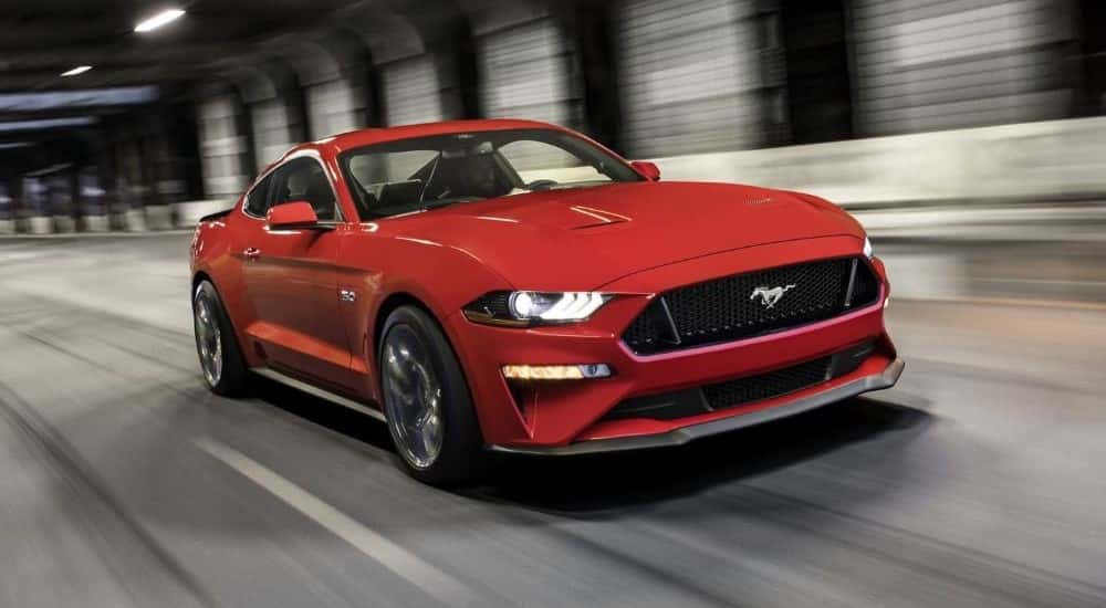 Red 2023 Ford Mustang GT speeding down the road.