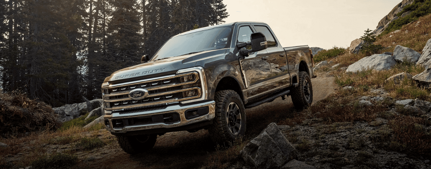 Grey 2026 Ford F-250 SD driving down a hill