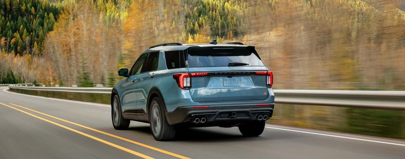 A light blue 2026 Ford Explorer® SUV driving on a mountain highway.