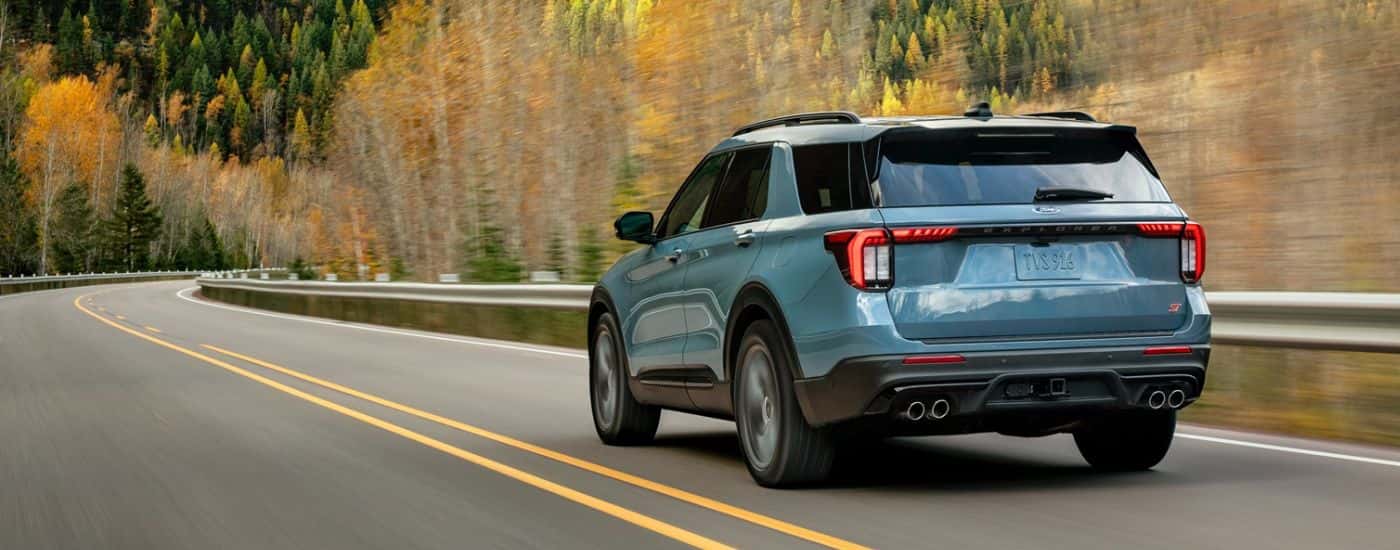 A light blue 2026 Ford Explorer® SUV driving on a mountain highway.