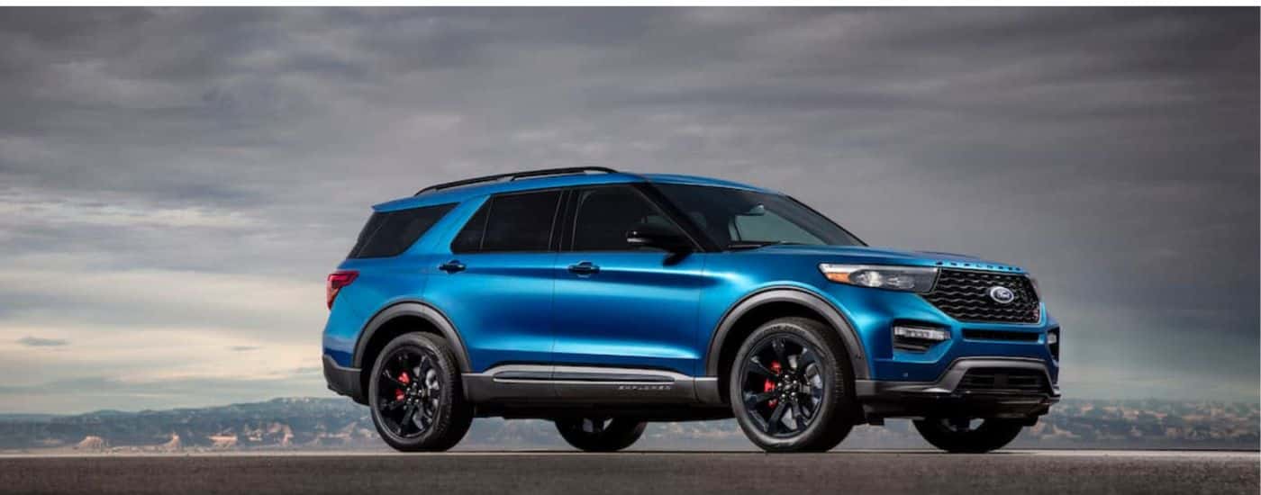 A blue 2020 Ford Explorer ST shown parked under a cloudy sky.