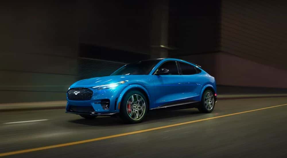 A blue 2026 Mustang Mach-E GT shown driving at night.