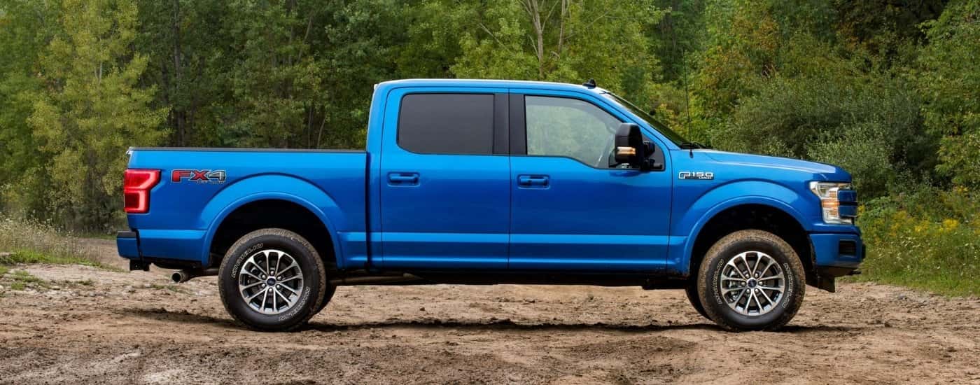 Blue 2019 Ford F-150 Lariat from the side parked off-road