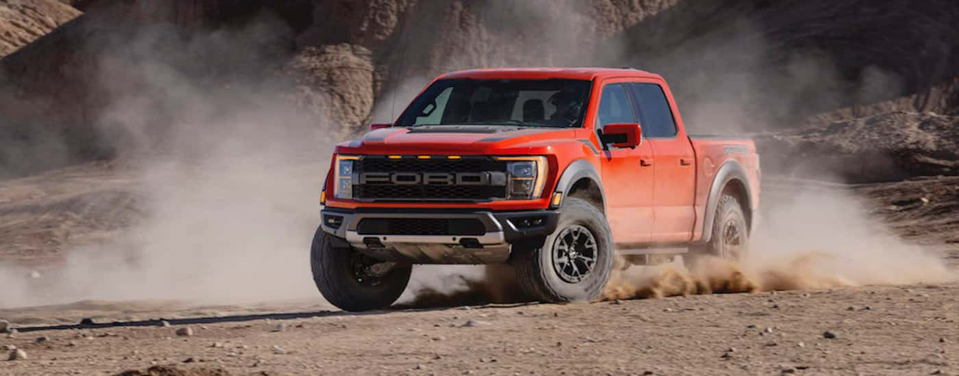 Orange 2021 Ford F-150 Raptor driving off-road