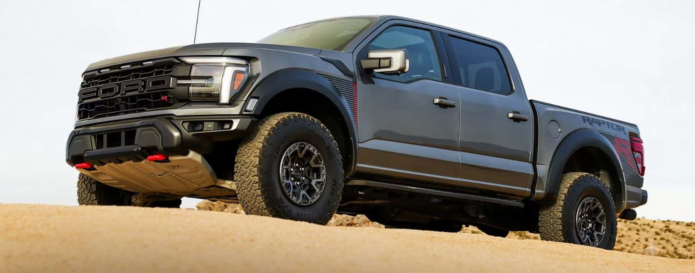 Grey 2026 Ford F-150 Raptor driving through sand