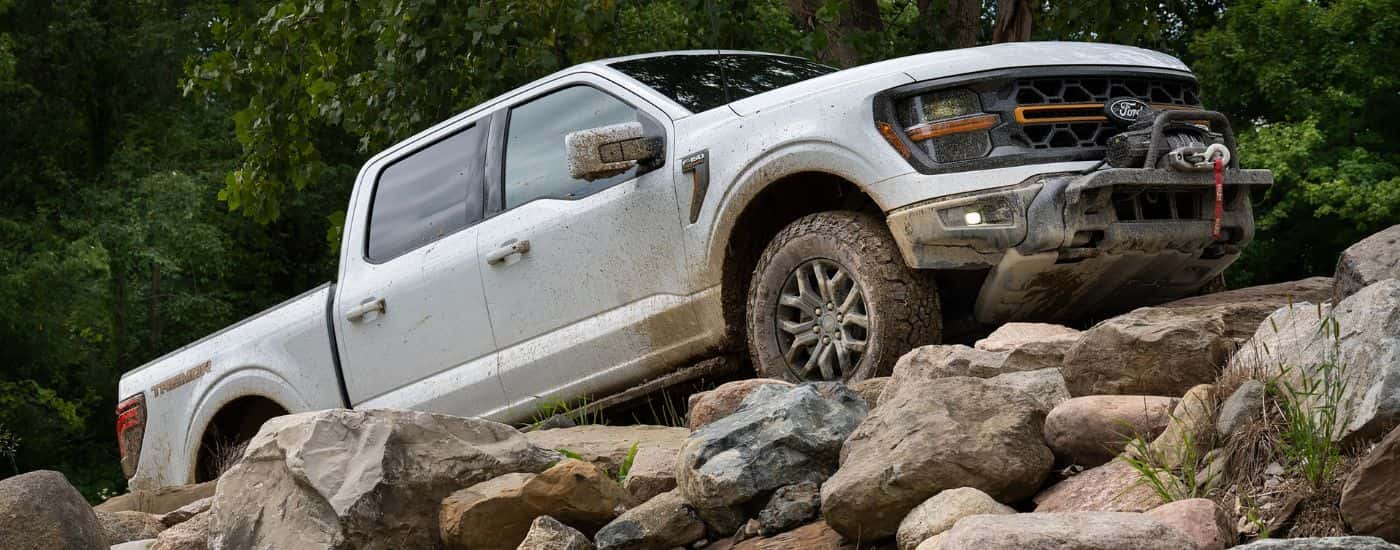 White 2026 Ford F-150 Tremor driving up rocks.