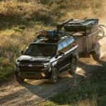 A black 2027 Ford Expedition towing a trailer offroad.