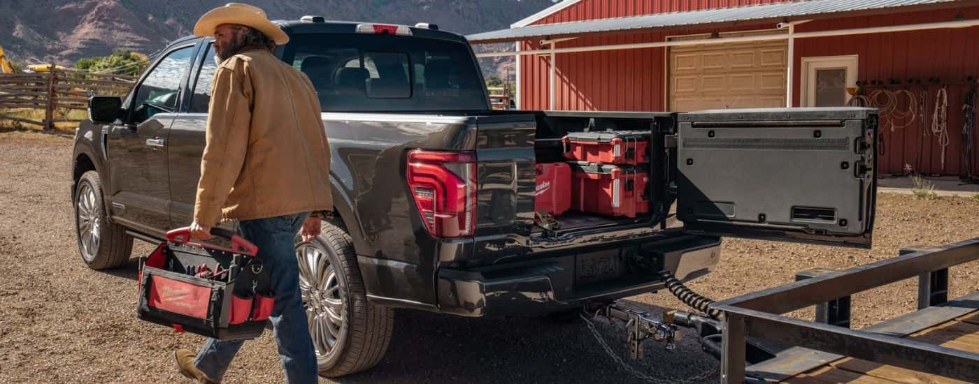 Black 2026 Ford F-150 rear view with tools in the bed.