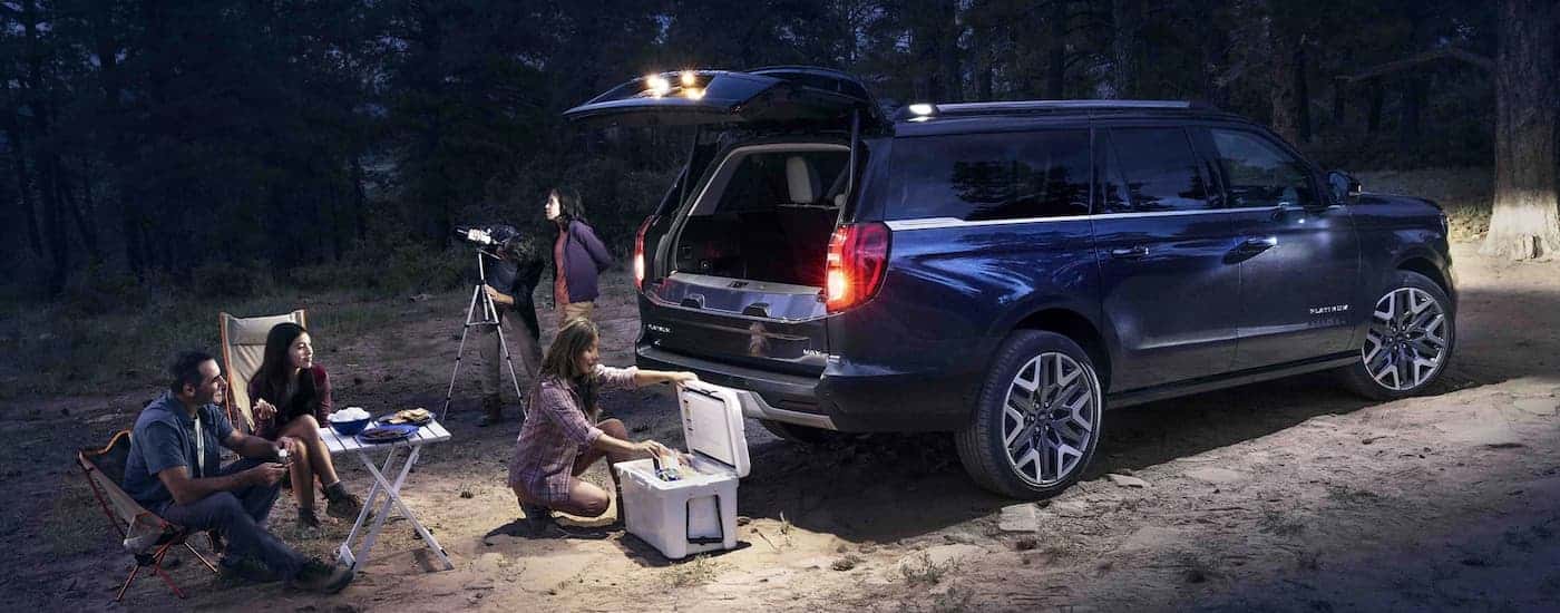 People setting up camp near a blue 2026 Ford Expedition.