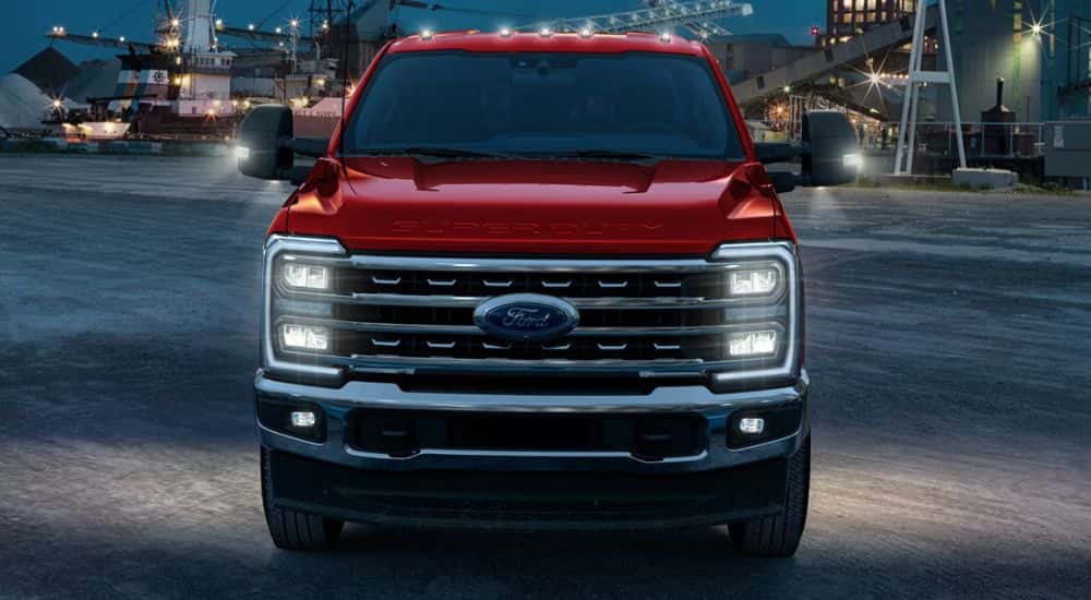 Front view of a red 2026 Ford F-250 at night on a construction site.