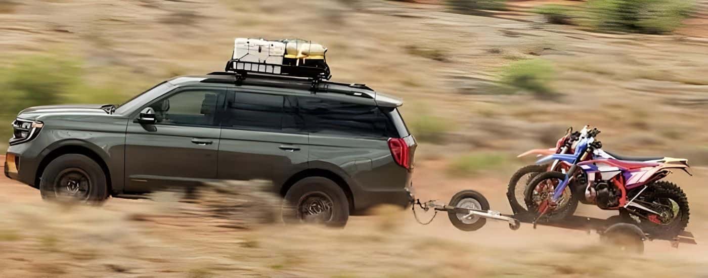 A green 2025 Ford Expedition Tremor is shown driving off-road.