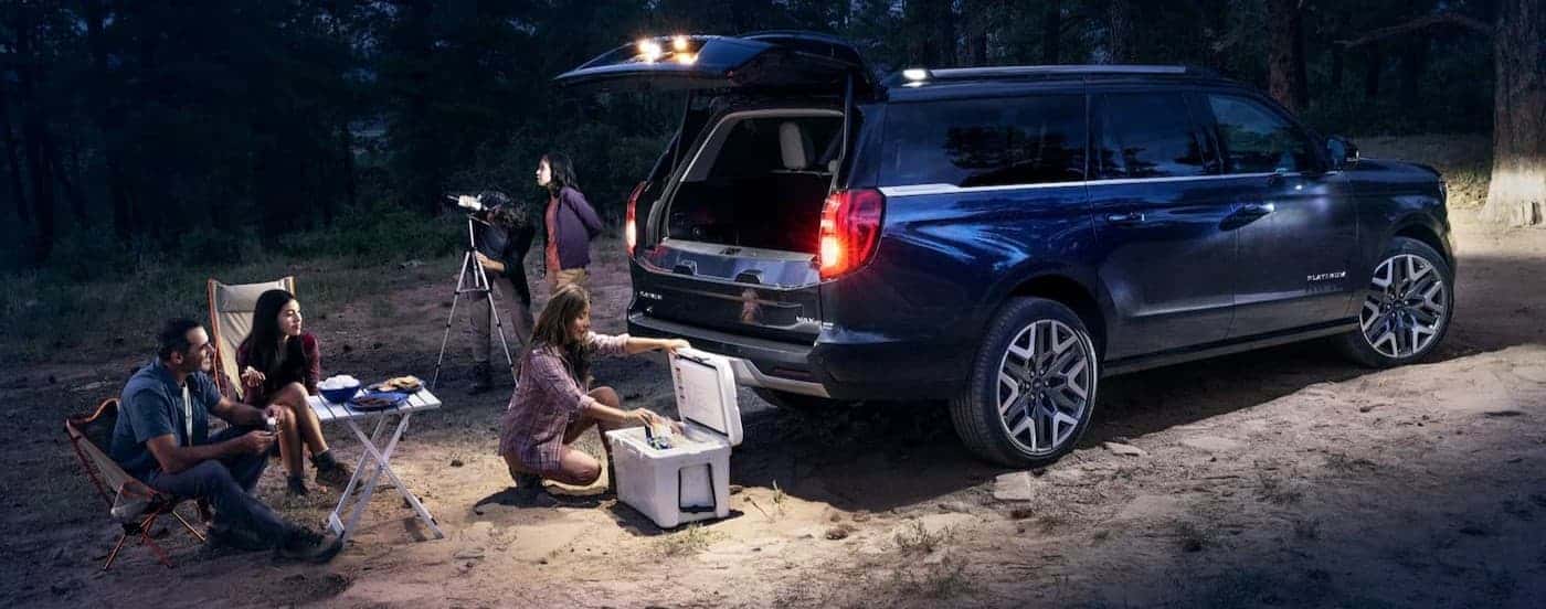 People gathered near a blue 2026 Ford Expedition MAX at night.