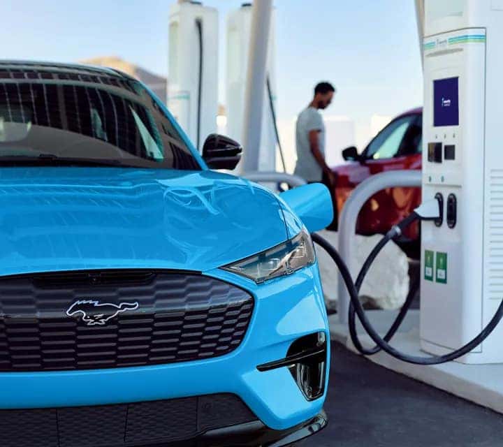 a ford mustang mach-e parked at a gas pump receiving gas