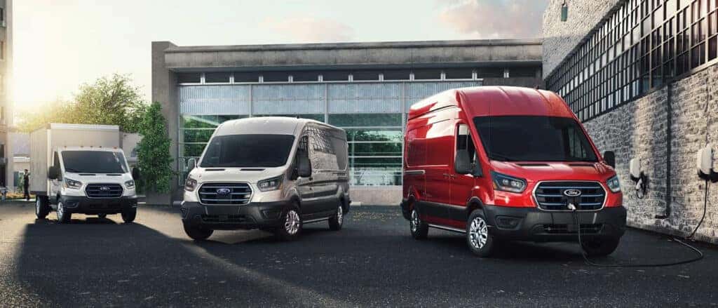 three e-transit vehicle trims parked in front of a warehouse