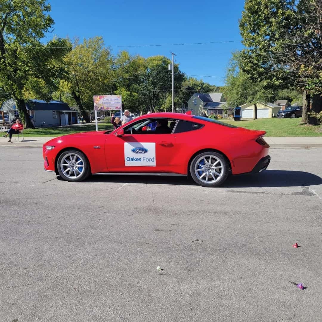 red car driving down road