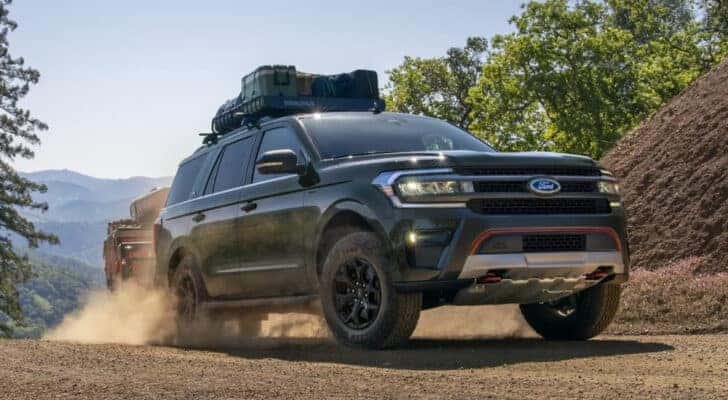 A green 2024 Ford Expedition Timberline is shown on a dusty trail.