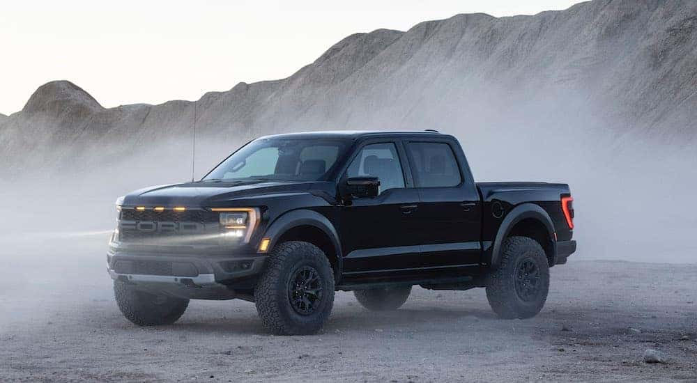 A black 2021 Ford F-150 Raptor parked off-road.