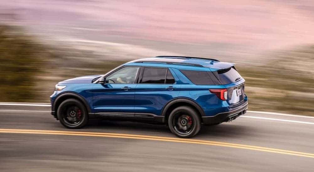 A blue 2020 Ford Explorer ST driving on a highway.