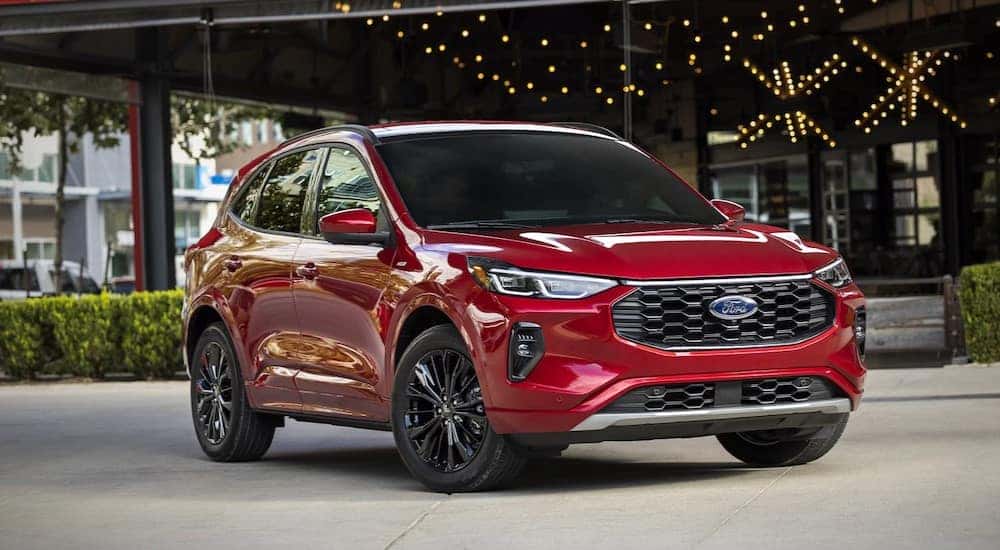 A red 2025 Ford Escape PHEV parked in a city.