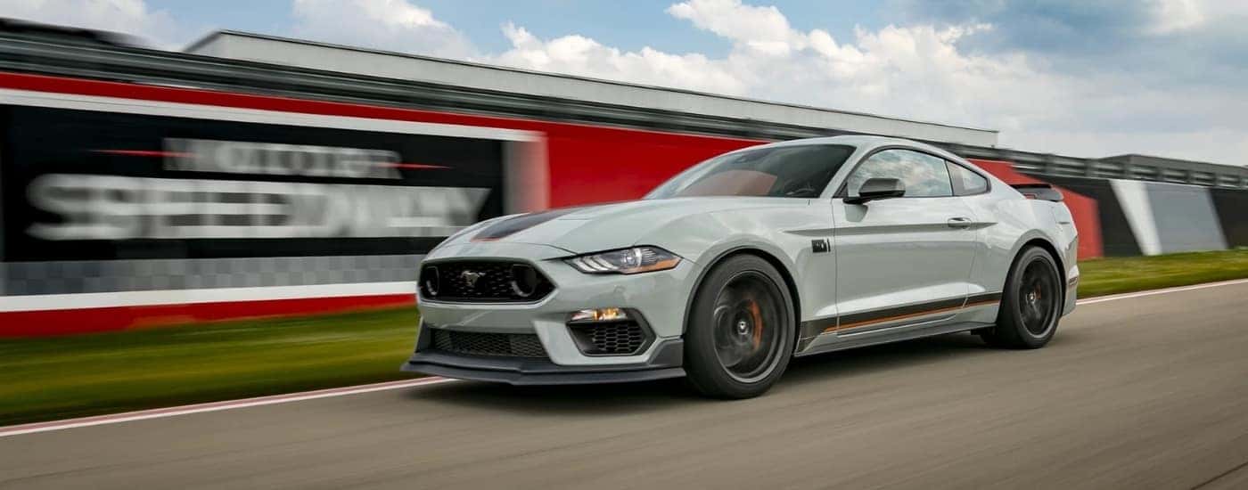 A grey 2022 Ford Mustang Mach 1 is driving on a racetrack.