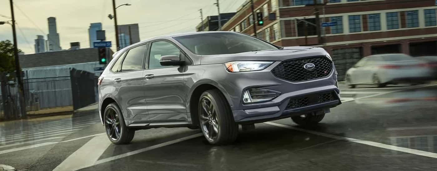 A grey 2023 Ford Edge ST is driving to look at a used for for sale.