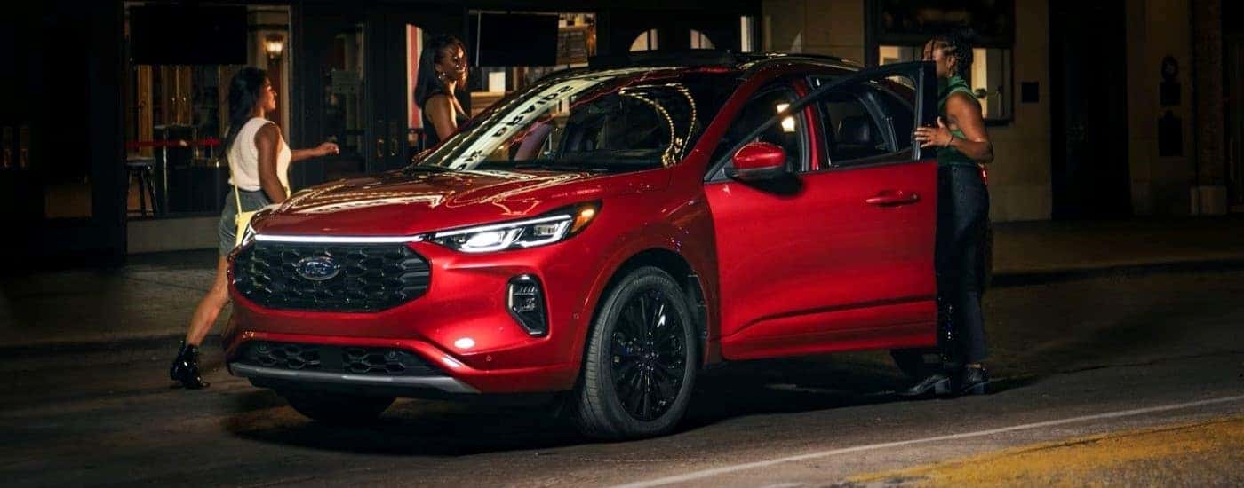 A red 2024 Ford Escape ST-Line for sale near me parked by a curb.