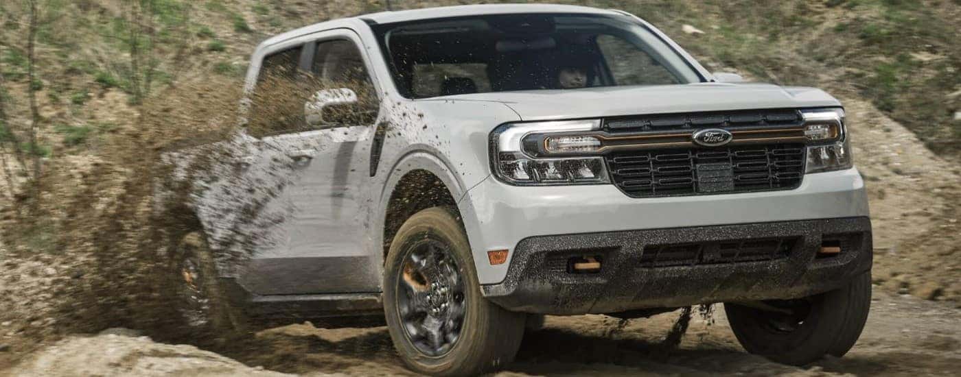 Grey 2024 Ford Maverick Tremor for sale near Greenville driving over a mud puddle.