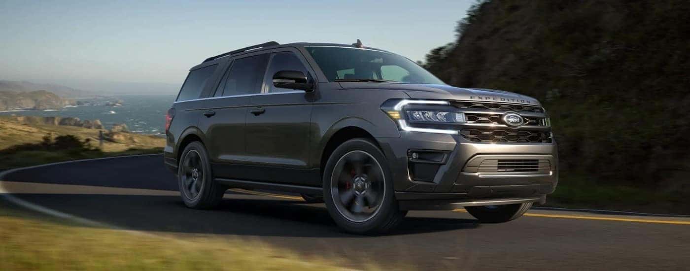 A grey 2025 Ford Expedition for sale near Boiling Springs driving on a costal road.