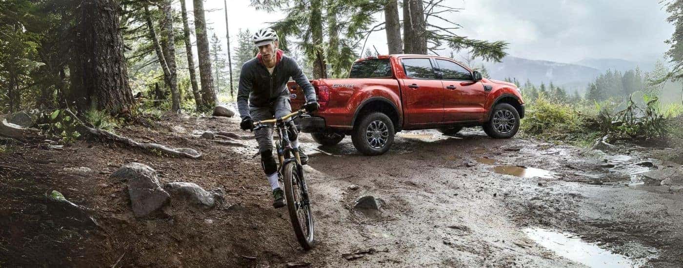 A biker near a red 2023 Ford Ranger Sport after looking at a used Ford for sale near Spartanburg.