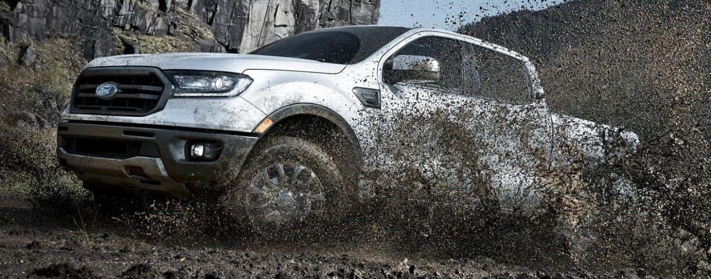 A silver 2023 Ford Ranger Lariat kicking up mud.