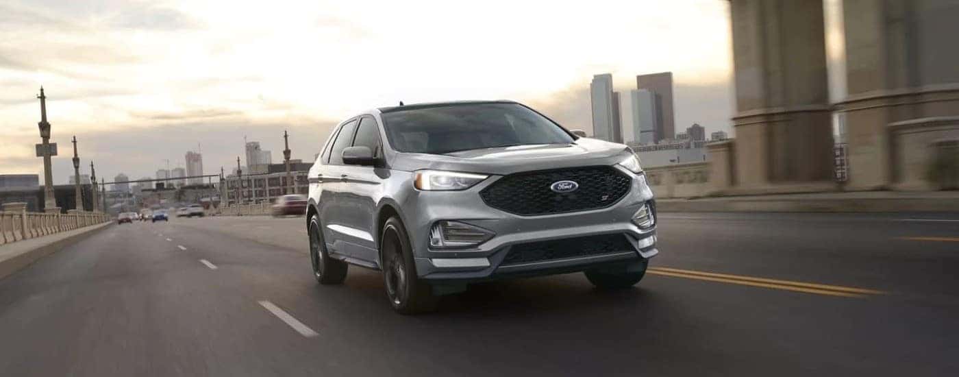 Silver 2023 Ford Edge ST driving on a city street