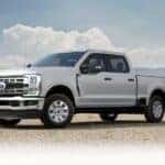 A silver 2025 Ford F-250 parked near a field.