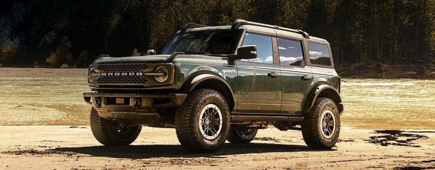 A green 2024 Ford Bronco for sale near Travelers Rest parked on a riverbank.
