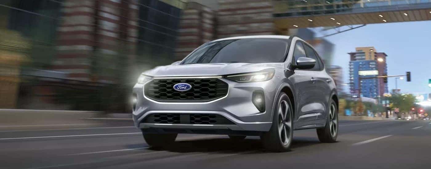 A silver 2025 Ford Escape driving in a city.