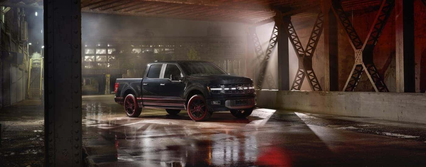 A black 2025 Ford F-150 Lobo outside of a factory.