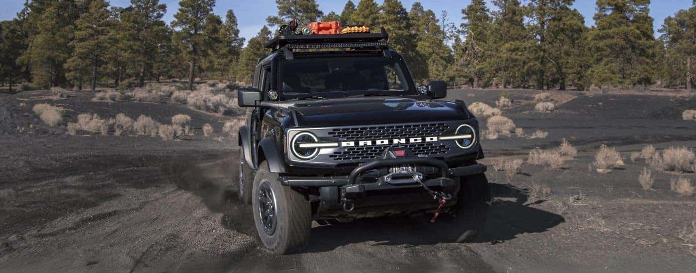A black 2024 Ford Bronco parked off-road on sand