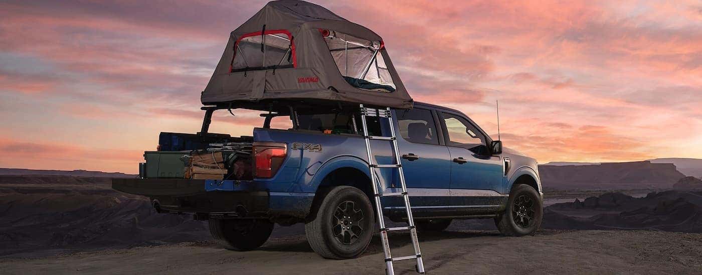 Tent set up on top of the bed of a blue 2025 Ford F-150 STX.