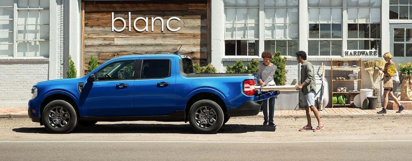 A blue 2025 Ford Maverick parked in a city.
