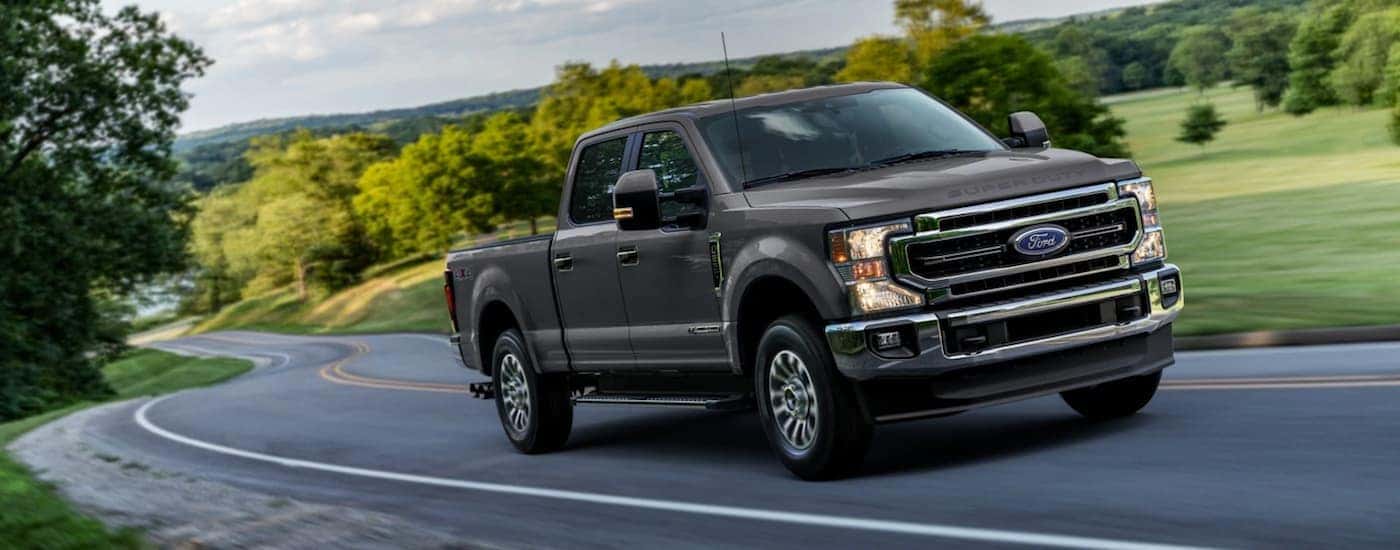 Black 2021 Ford F-250 Super Duty driving around a bend.