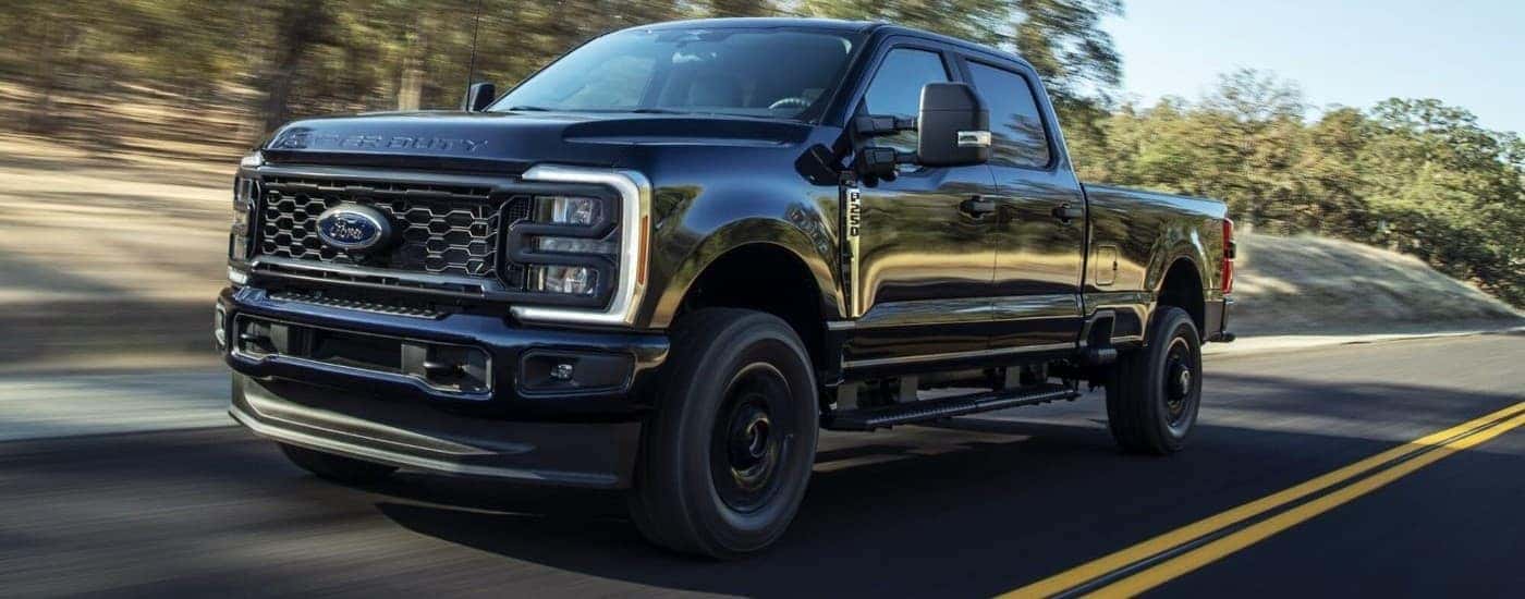 Black 2023 Ford F-250 STX driving down the road