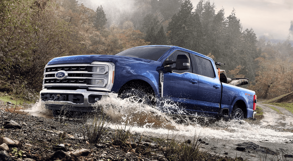 Blue 2026 Ford F-250 Super Duty driving through a creek