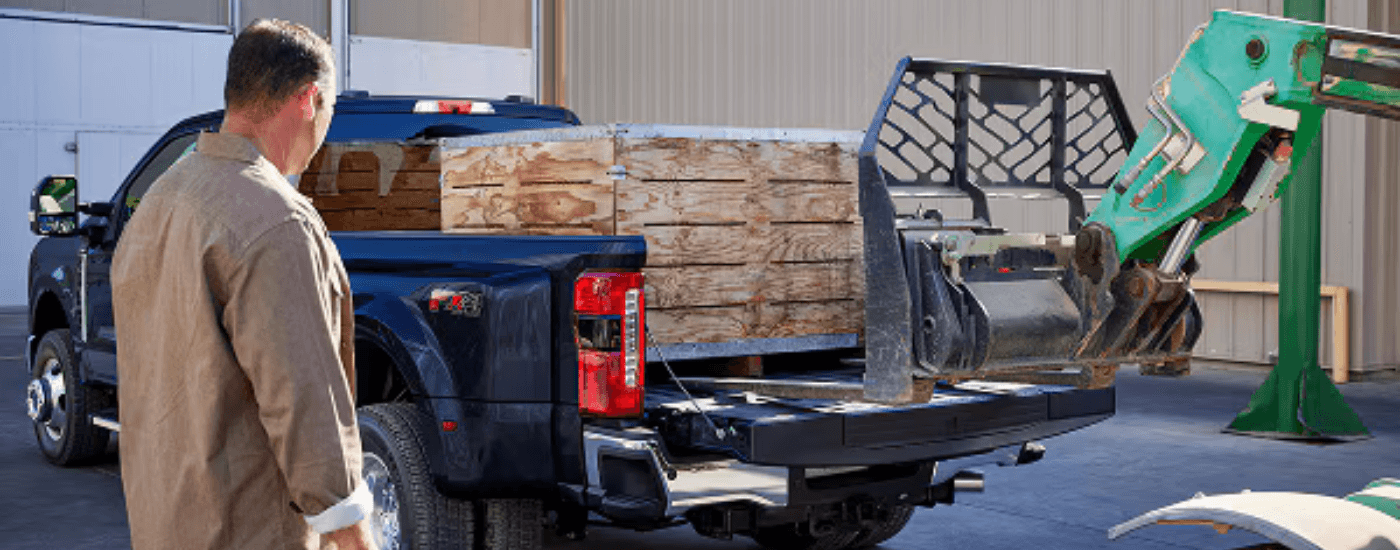 Blue 2026 Ford F-350 Super Duty being loaded with a crate