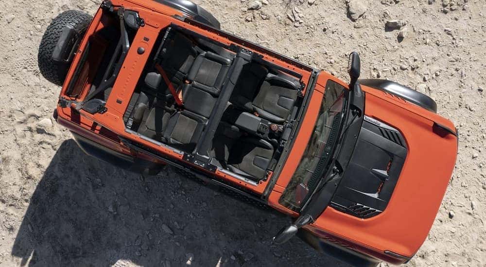 An orange 2022 Ford Bronco is parked off-road.