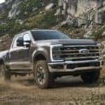 A grey 2023 Ford F-350 is shown from the front off-roading.