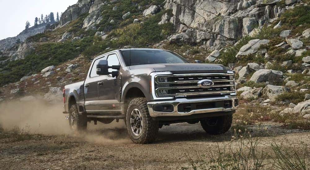 A grey 2023 Ford F-350 is driving off-road.