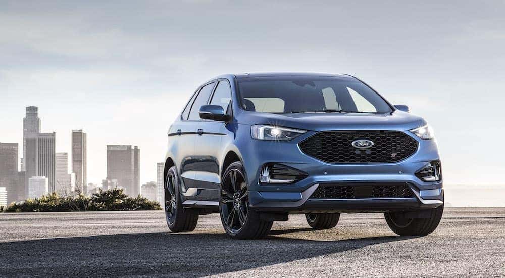 A blue 2019 Ford Edge ST parked near a city.