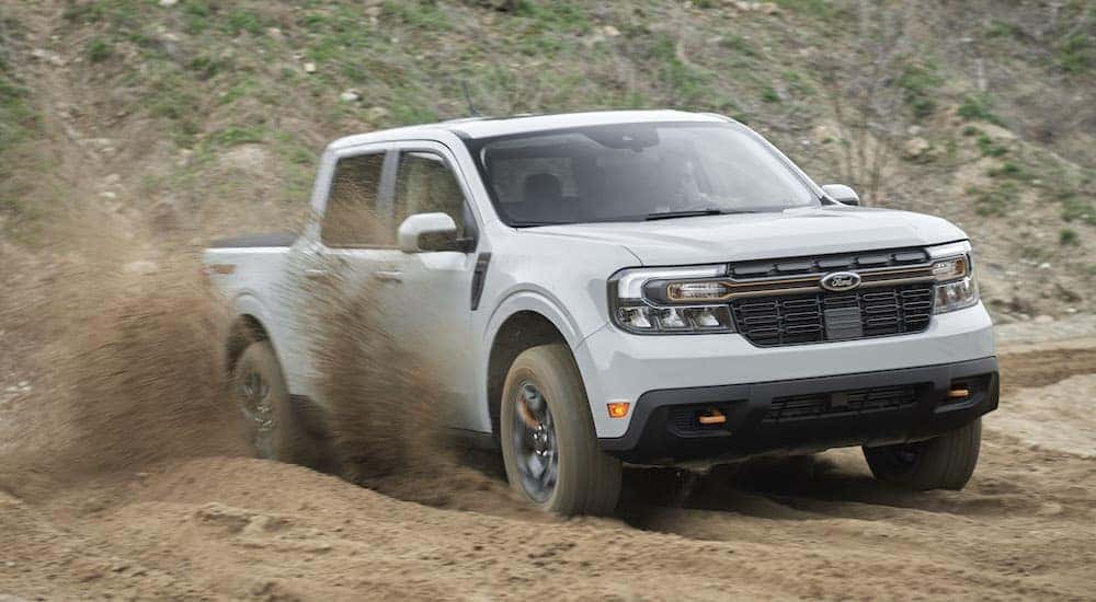 A grey 2023 Ford Maverick is driving to a Ford dealer in Perry.