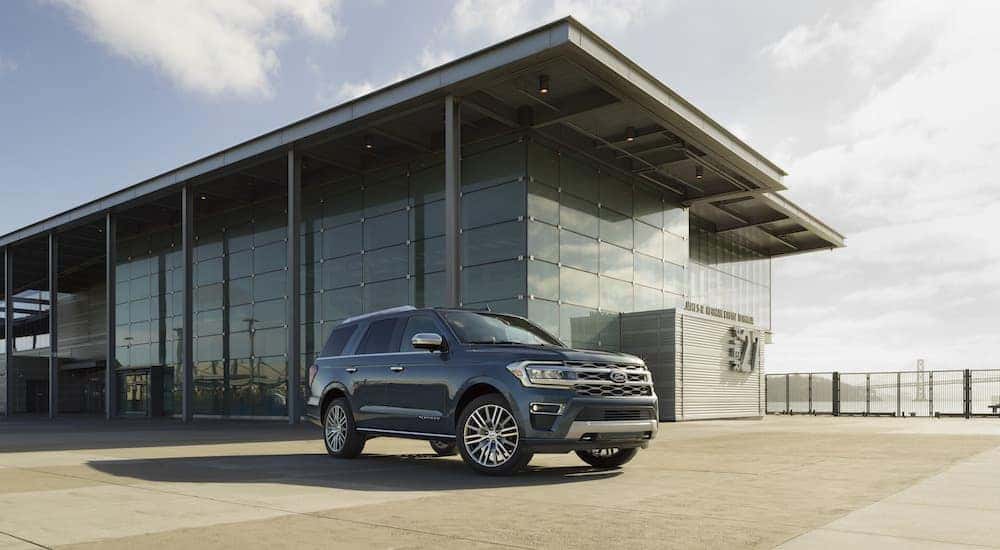 A 2022 Ford Expedition Platinum is parked in front of a Ford dealership near Grand Ledge.